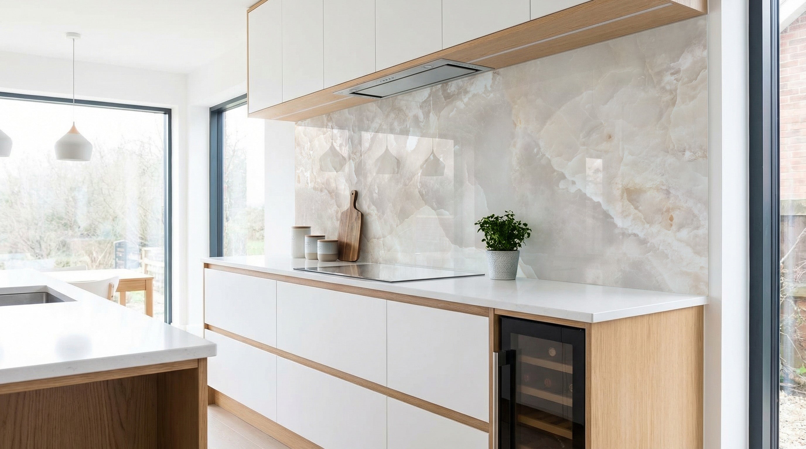 Moderne Küche mit weißen Schränken, Holzakzenten und einer Küchenrückwand von Heller Marmor in der Farbe „Creme-Grau“.