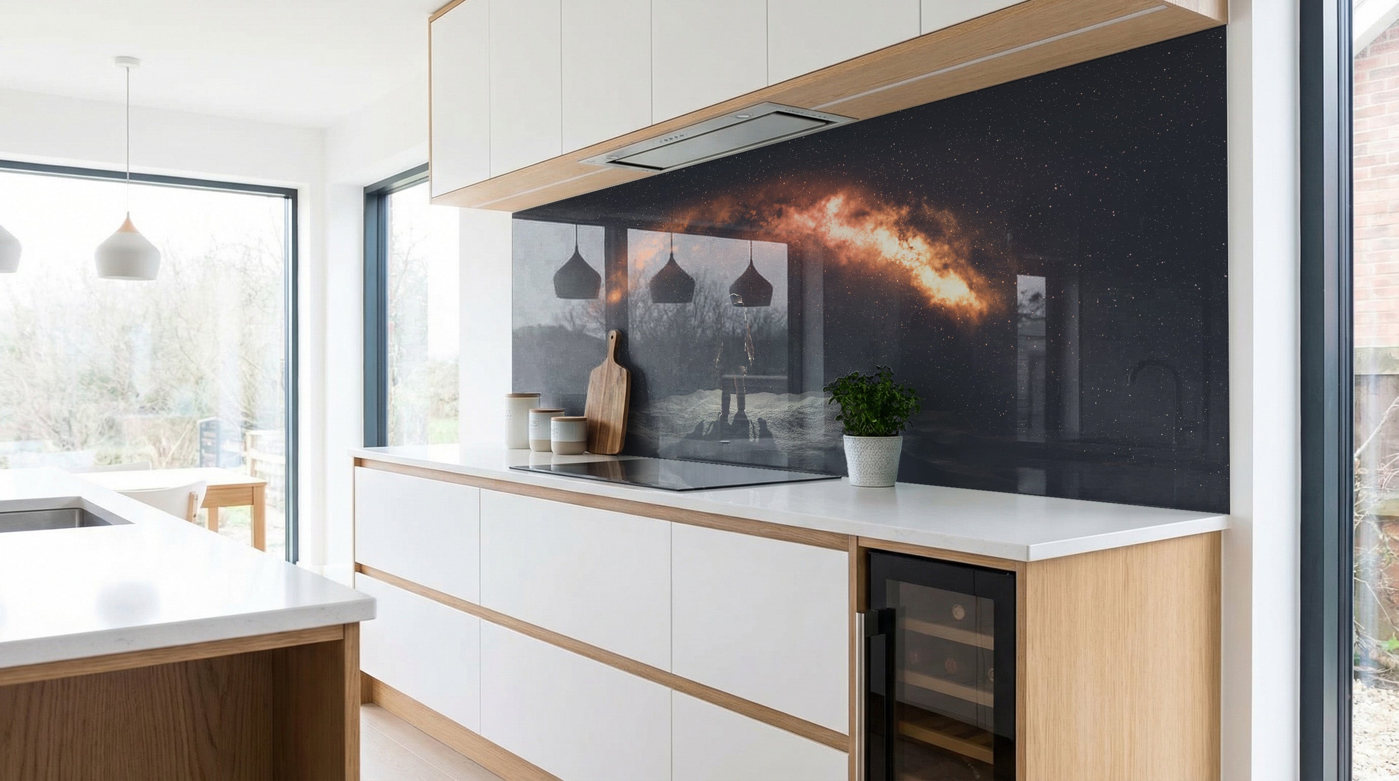 Moderne Küche mit weißen Schränken und einer leuchtenden „Galaxie-Nachthimmel“-Küchenrückwand von glasposter.com.