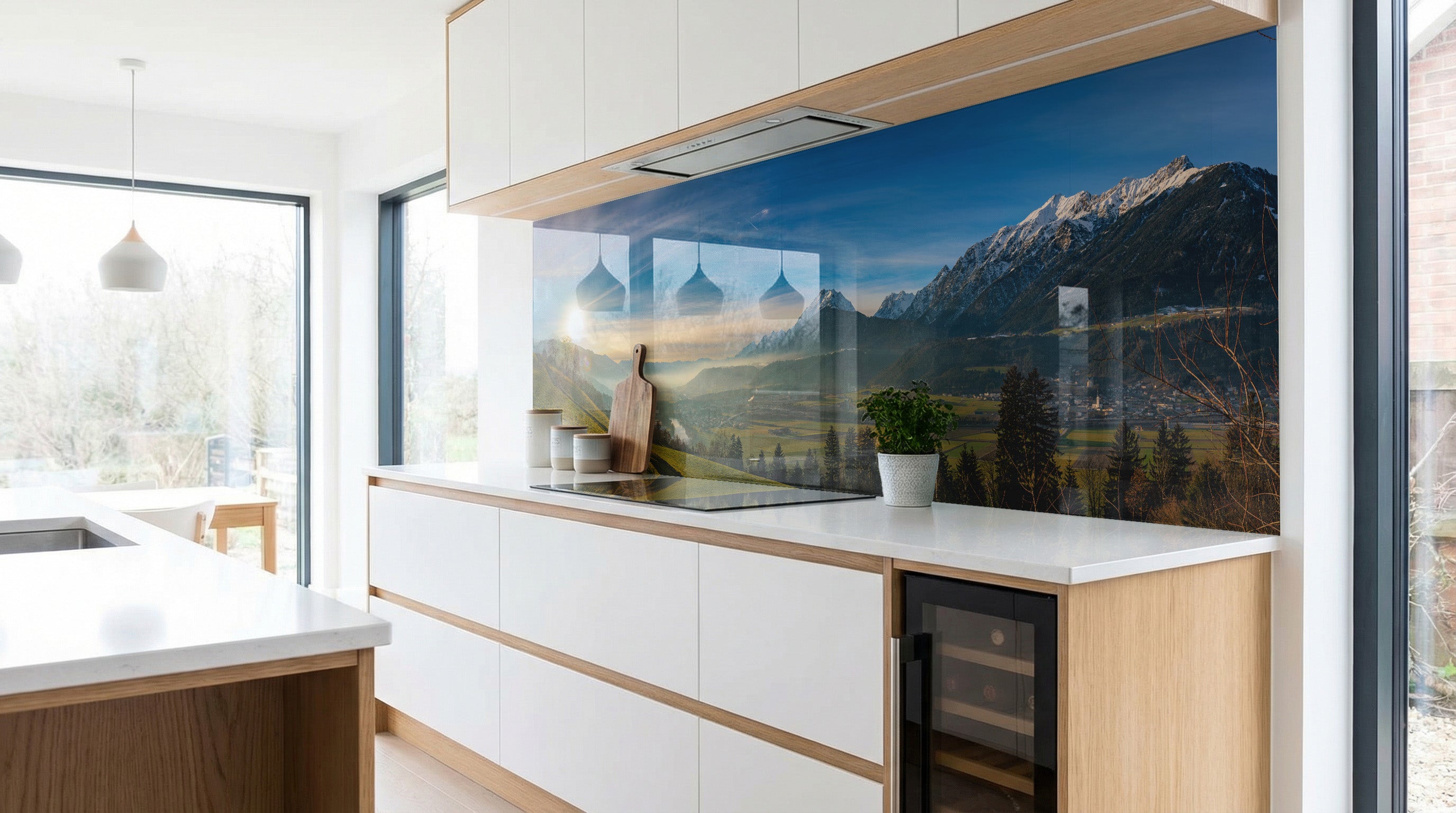 Moderne Küche mit weißen Schränken und dem Alpenpanorama „Schneegipfel Berghütte“ von glasposter.com.