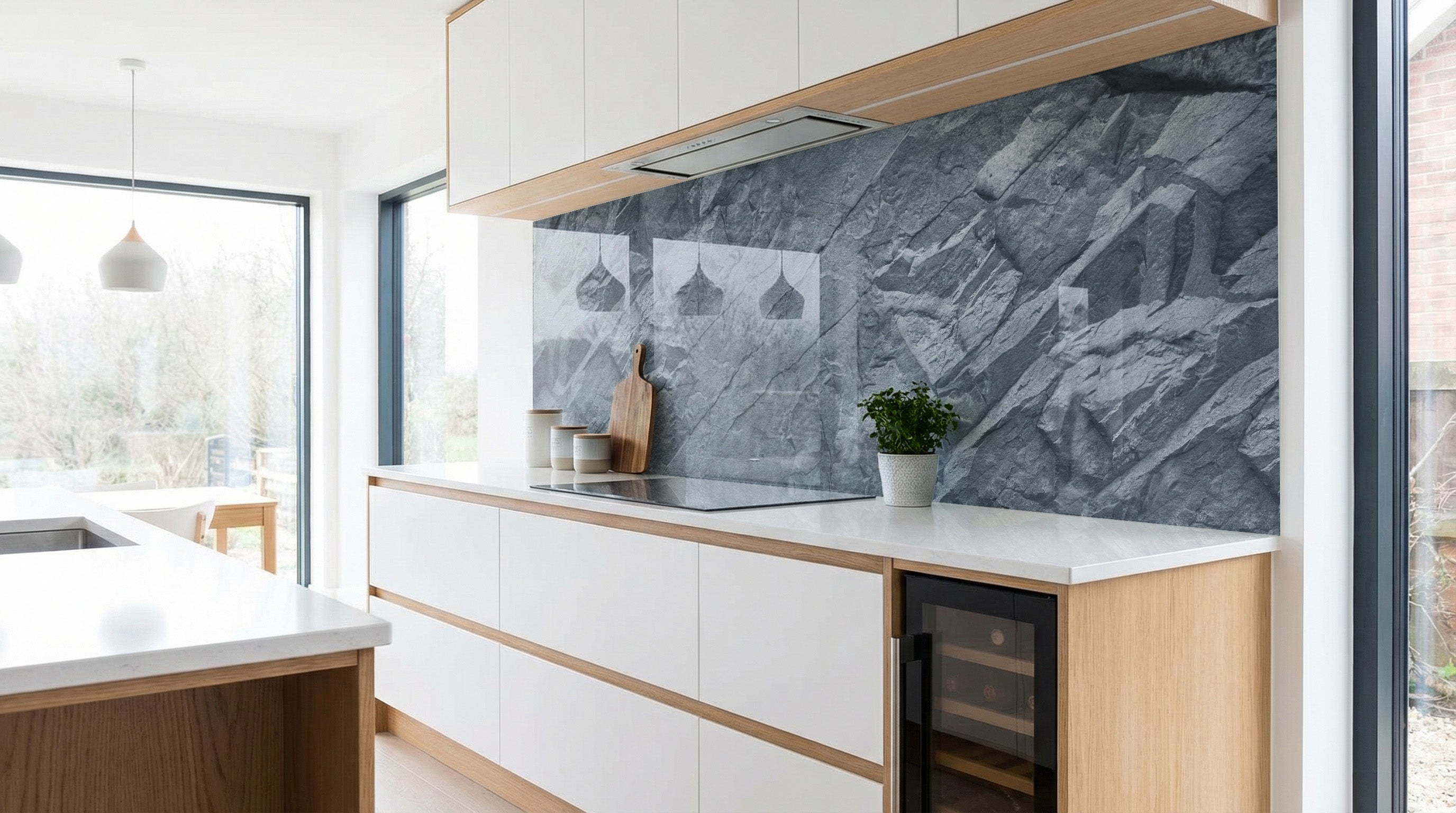 Moderne Küche mit weißen Schränken, Holzakzenten und einer Küchenrückwand „Felswand Granit Grau“ von glasposter.com.