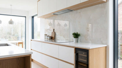 Moderne Küche mit weißen Schränken, Holzakzenten und einer Küchenrückwand in Marmor-Optik Grau-Beige von glasposter.com.