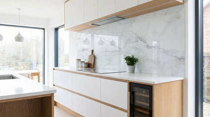 Moderne Küche mit weißen Schränken, Holzakzenten und einer Küchenrückwand von glasposter.com in der Ausführung „Marmor Weiß Grau Adern“.