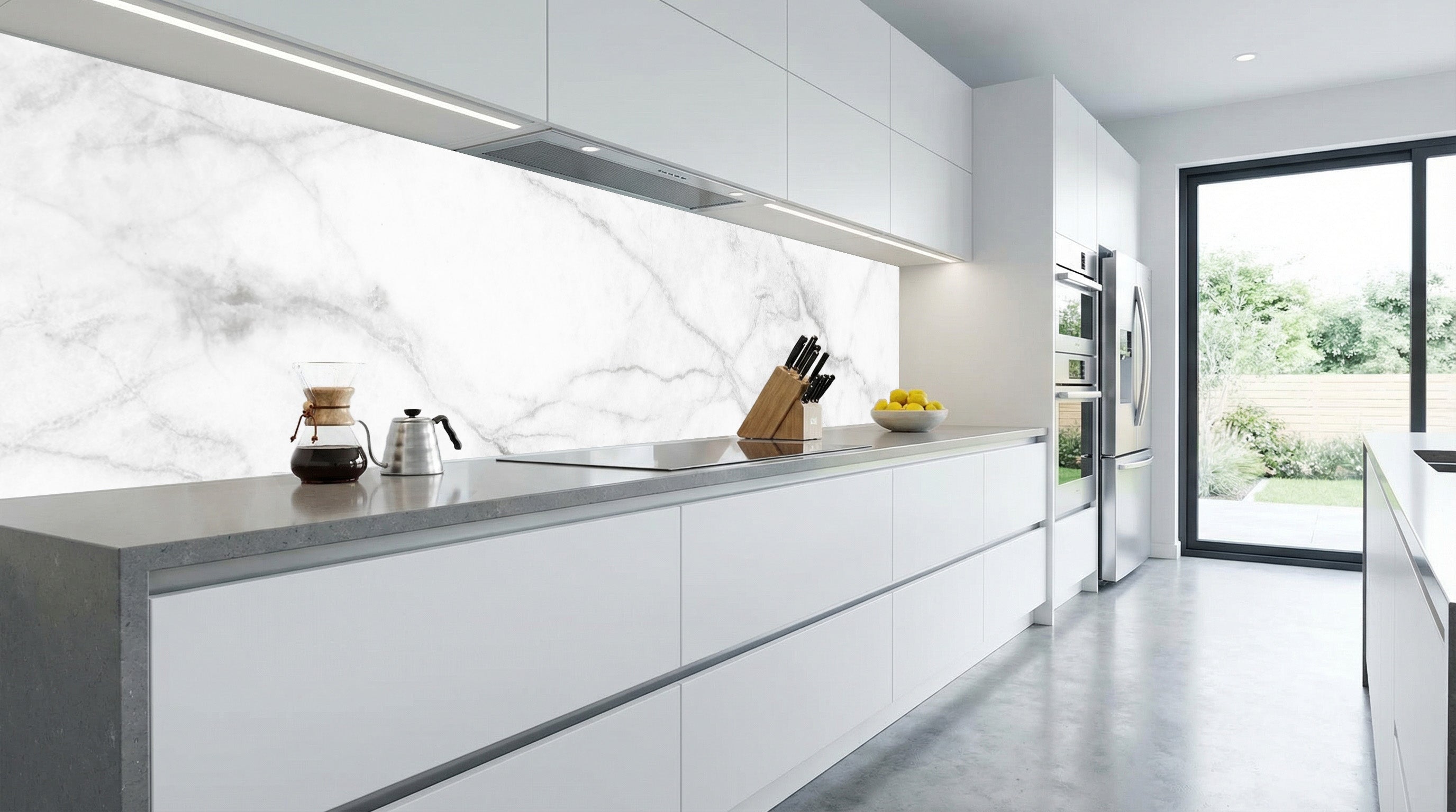 Moderne weiße Küche mit einer Küchenrückwand von glasposter.com – „Marmor Weiß Grau Adern“ – und Blick in den Garten.