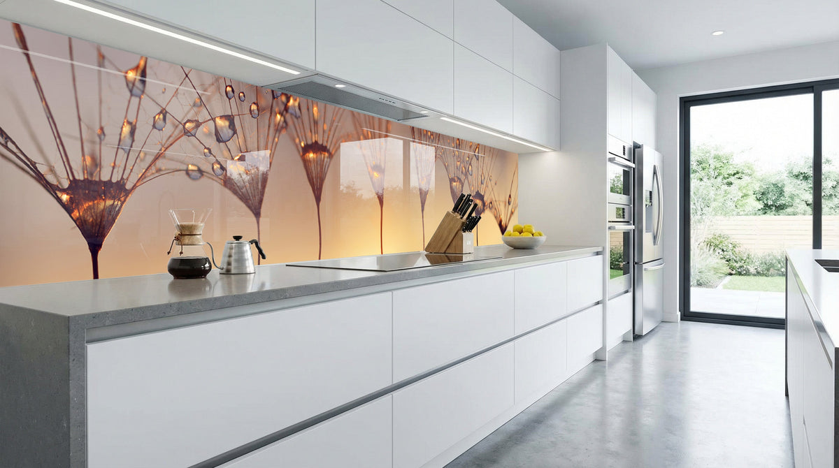 Moderne Küche mit weißen Schränken, grauen Arbeitsplatten und einer „Pusteblumen Sonnenuntergang“-Fliesenwand.
