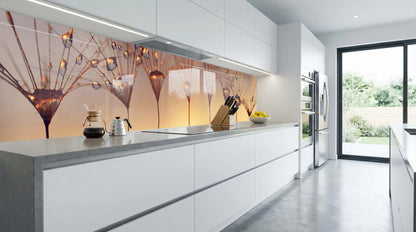 Moderne Küche mit weißen Schränken, grauen Arbeitsplatten und einer „Pusteblumen Sonnenuntergang“-Fliesenwand.
