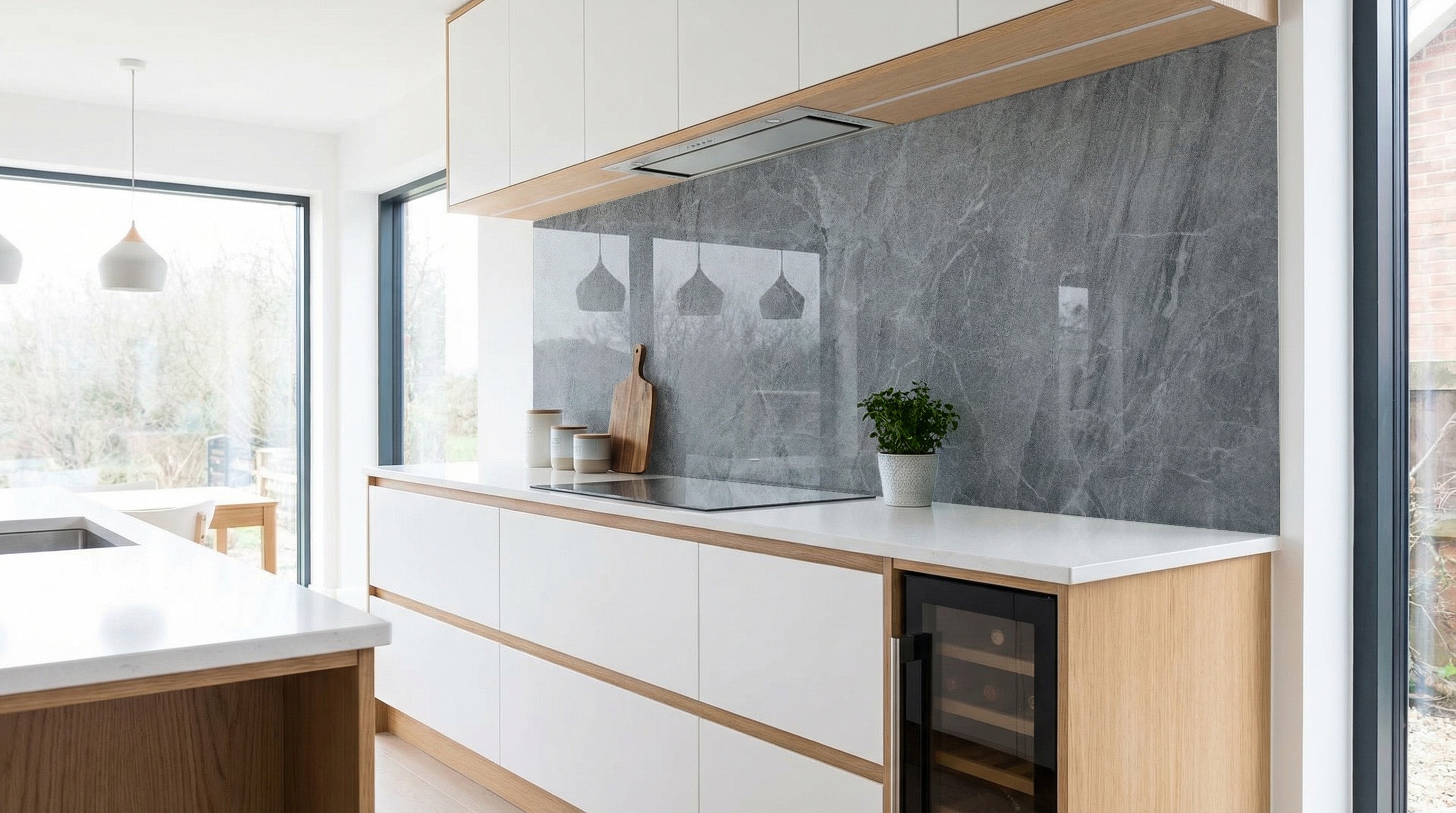 Moderne Küche mit weißen Schränken, Küchenrückwand in Marmoroptik Dunkelgrau-Weiß von glasposter.com.