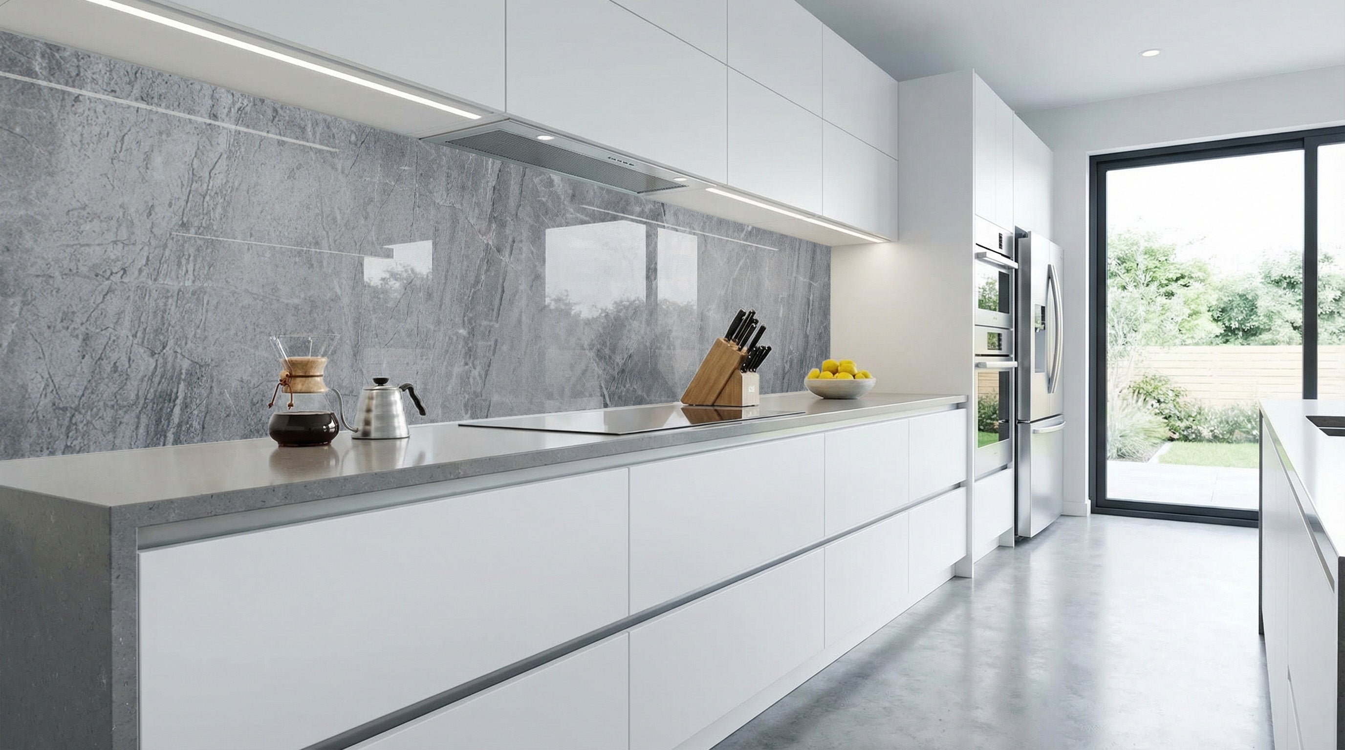 Moderne Küche mit grauen Arbeitsplatten, Küchenrückwand – Marmoroptik von glasposter.com, große Fenster.