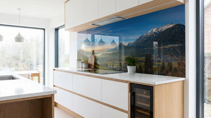 Moderne Küche mit weißen Schränken und dem Alpenpanorama „Schneegipfel Berghütte“ von glasposter.com.