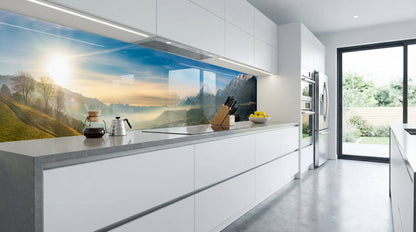 Moderne Küche mit weißen Schränken und einer Küchenrückwand „Alpenpanorama Schneegipfel“ von glasposter.com.