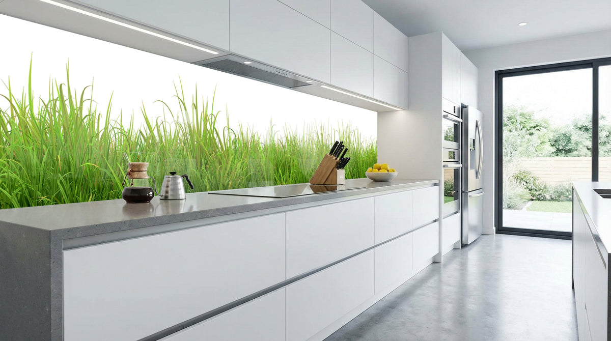 Moderne weiße Küche mit großem Fenster, hellem Licht und Küchenrückwand – „Wiesengrün“ von glasposter.com.