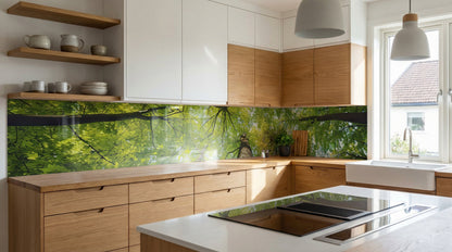 Moderne Küche mit Holzschränken, weißen Arbeitsplatten und einer Glasrückwand von glasposter.com mit Baumkronen-Motiv.