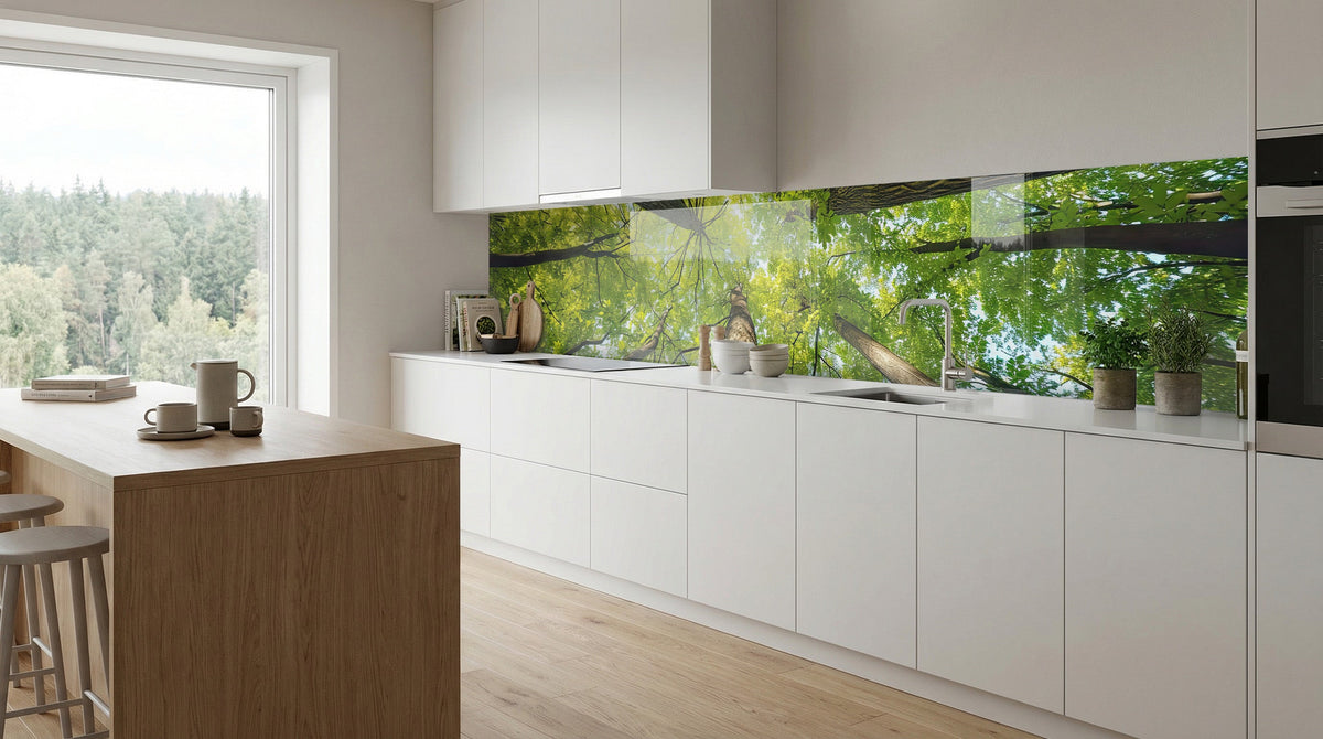 Moderne weiße Küche mit Holzakzenten, ausgestattet mit einer Küchenrückwand „Blick in die Baumkronen“ von glasposter.com.