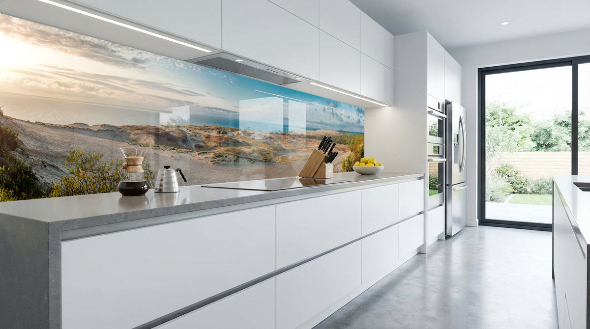 Sonnendurchflutete, moderne weiße Küche mit einer Küchenrückwand von glasposter.com – „Dünenlandschaft“.