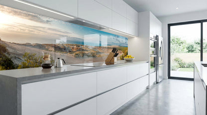 Sonnendurchflutete, moderne weiße Küche mit einer Küchenrückwand von glasposter.com – „Dünenlandschaft“.