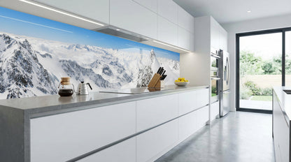 Moderne weiße Küche mit Küchenrückwand – „Schneebedeckte Berge“ von glasposter.com, im Sonnenlicht erstrahlend.