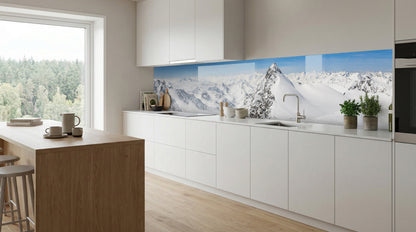 Moderne weiße Küche mit einer Küchenrückwand – „Schneebedeckte Berge“ von glasposter.com über den Arbeitsplatten.